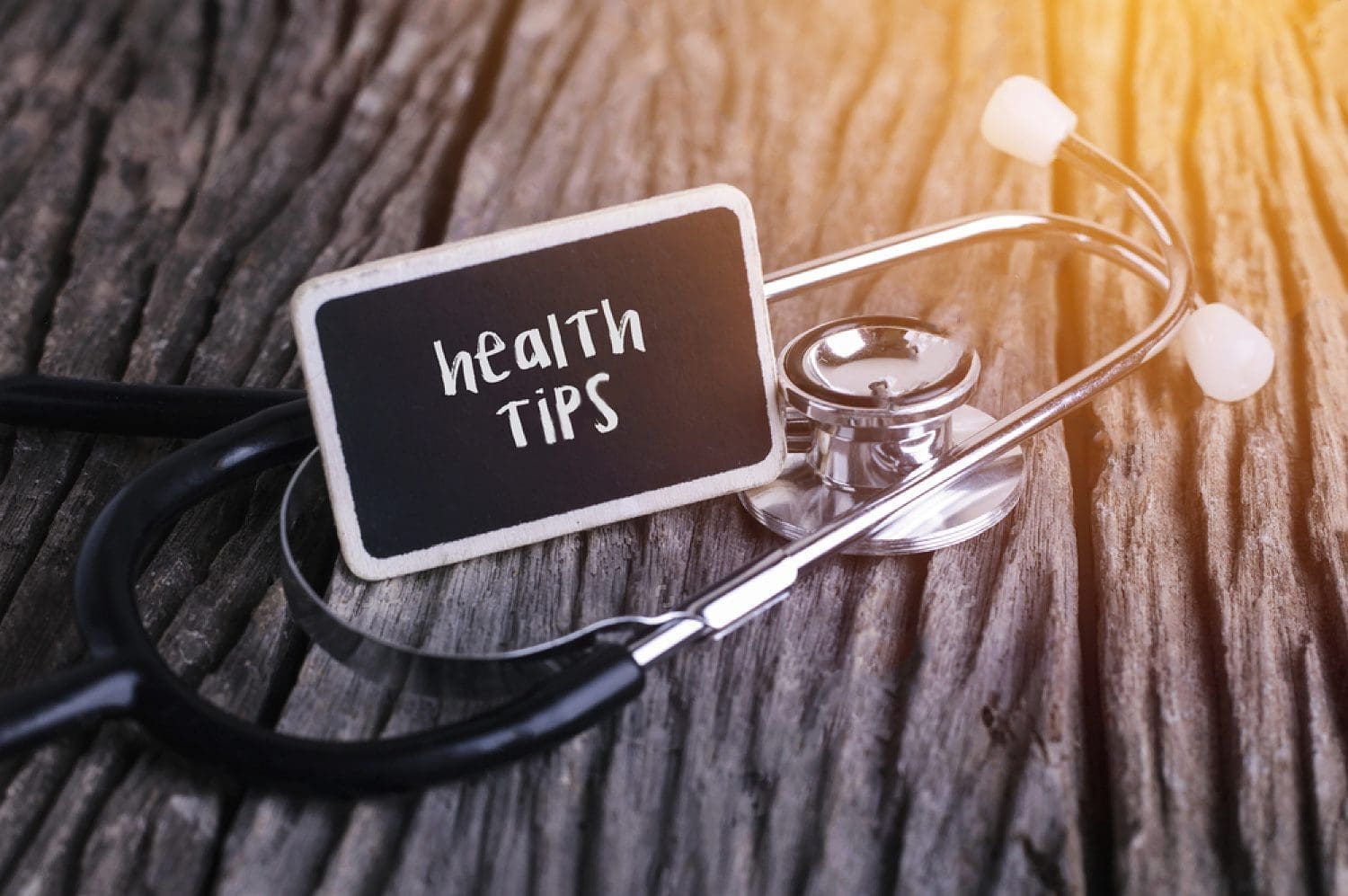 table with stethoscope and mini chalkboard that says health tips